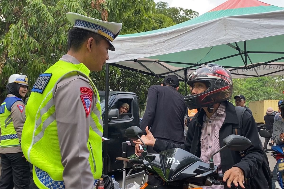 Polisi menenangkan pengendara motor yang emosi saat kena tilang uji emisi di Jakarta Barat 