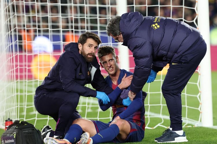 Anggota staf medis merawat gelandang Barcelona Dani Olmo yang cedera setelah mencetak gol pada laga Liga Spanyol antara Barcelona dan Atletico Madrid di Stadion Camp Nou di Barcelona pada 2 Desember 2025.
