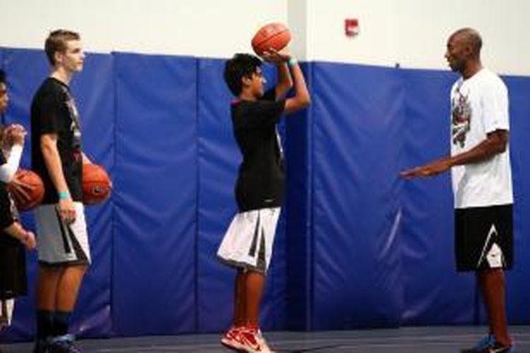 Pebasket LA Lakers, Kobe Bryant (kanan) memimpin latihan di Gems American Academy di Abu Dhabi, Kamis (26/9/2013). Bryant datang dalam rangka promosi waspada diabetes di Uni Emirat Arab.