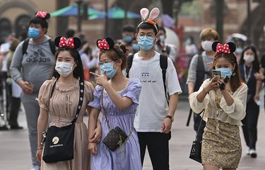 Pengunjung mengenakan masker saat mendatangi taman hiburan Disneyland, Shanghai, China, yang baru dibuka kembali, Senin (11/5/2020). Shanghai Disneyland resmi kembali dibuka setelah ditutup selama 4 bulan akibat pandemi virus corona.