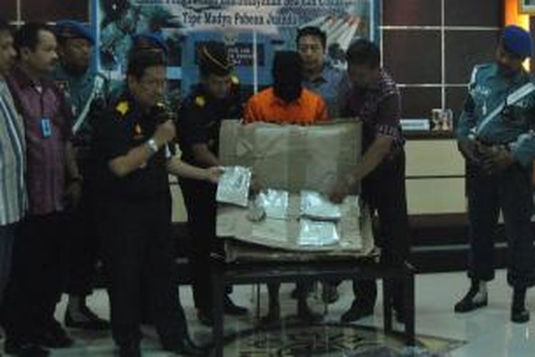 Tersangka bersama barang bukti narkoba sabu-sabu seberat 1 kg yang dibungkus dalam delapan plastik aluminium saat digelar di KPP Bea Cukai tipe Madya Pabean Juanda, Jumat (11/10/2013). 