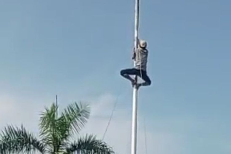 Tangkapan layar seorang petani memanjat tiang bendera saat upacara 17 Agustus 2022 di Kecamatan Jayakerta, Kabupaten Karawang, Jawa Barat.