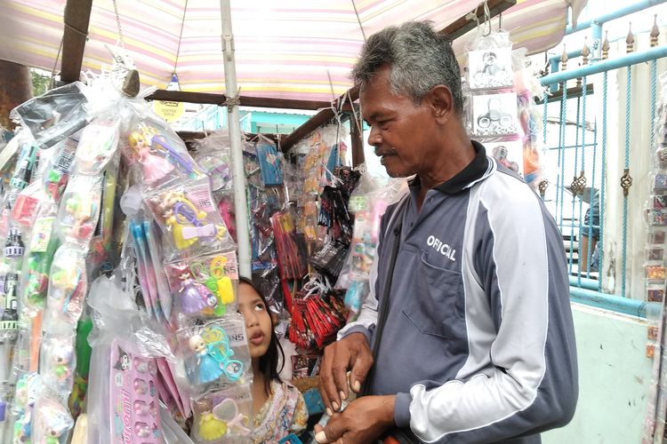 Juhari (74) saat menjual mainan di Surabaya, Jawa Timur, Kamis (23/1/2025)