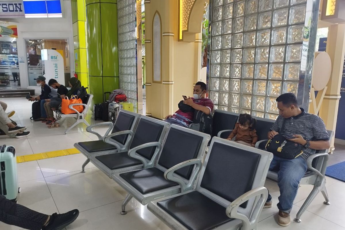 Turisa (30) dan anaknya saat menunggu jadwal keberangkatan untuk mudik ke Cirebon di Stasiun Gambir, Jakarta Pusat, Selasa (18/4/2023). (KOMPAS.com/XENA OLIVIA)