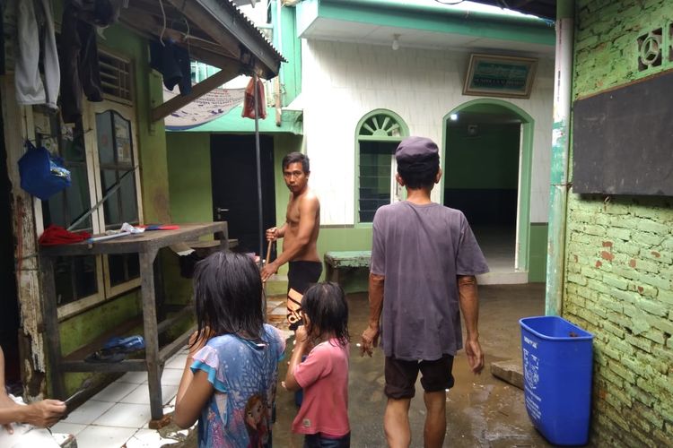 Beberapa warga Kampung Melayu yang sudah mulai membersihkan rumah walaupun masih diimbau untuk waspada.