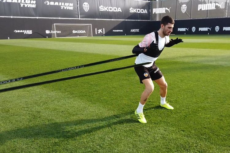 Pemain Valencia, Cristiano Piccini, melakukan latihan individu dengan memakai sistem GPS.