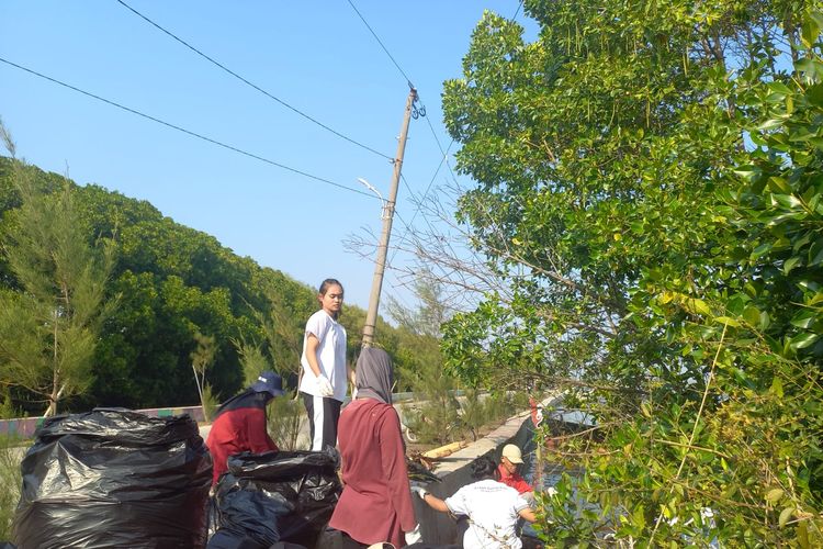 Volunteer Komunitas Back Ind sedang mengumpulkan sampah di bibir Pantai Pantai Mangunharjo, Kota Semarang, Minggu (20/8/2023).