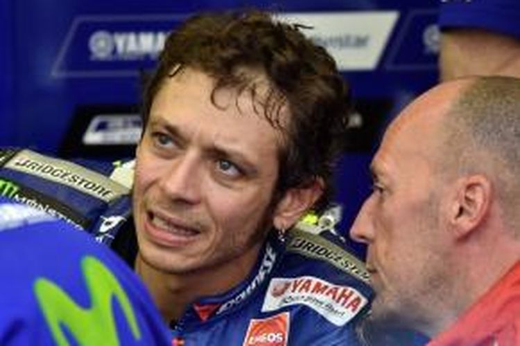 Pebalap Movistar Yamaha asal Italia, Valentino Rossi, berdiskusi dengan tim saat menunggu sesi kualifikasi GP Jepang di Sirkuit Twin Ring Motegi, Sabtu (10/10/2015).