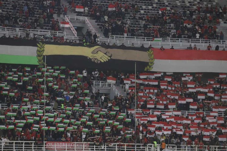 Sejumlah suporter secara serentak membentangkan bendera merah putih dan bensera Palestina dalam laga FIFA Matchday antara Indonesia versus Palestina di Stadion Gelora Bung Tomo, Surabaya, Rabu (14/6/2023) malam.