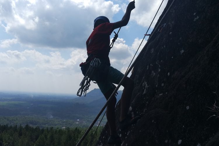 Salah satu peserta Indonesia Climbimng Festival ketika berada di tebing Gunung Sepikul dengan pemandangan indah,yang berada di desa Watuagung Kecamatan Watulimo Kabupaten Trenggalek Jawa Timur Sabtu (22/06/2019) kemarin.