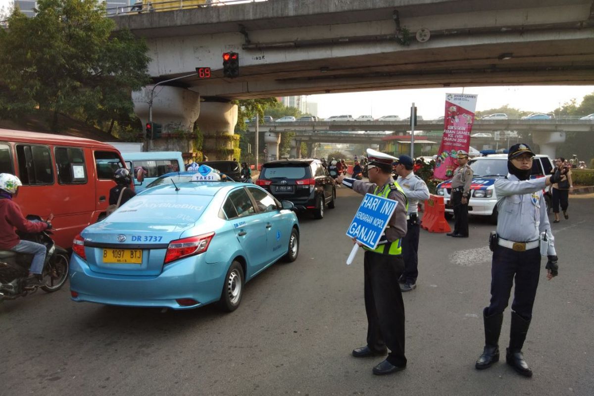 Tim Kepolisian Lalu Lintas Melakukam Pengimbauan Pada Pengguna Kendaraan Pelat Genap, di MT Haryono, Jakarta Timur, Senin (9/7/2018).