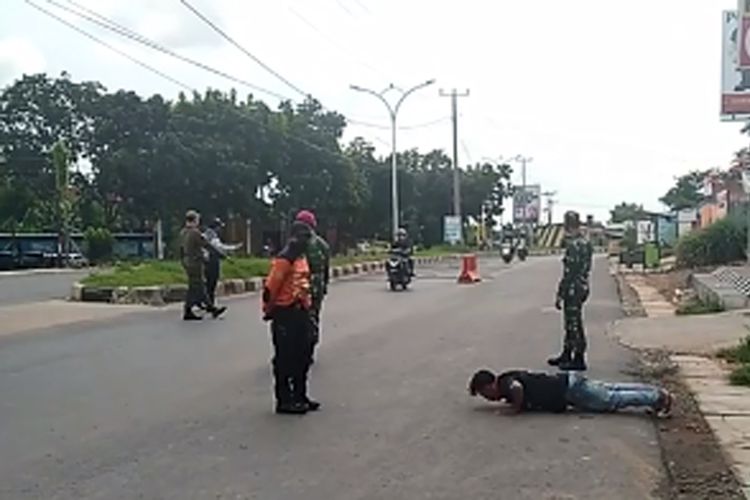 Seorang warga dihukum push up oleh petugas gabungan di Posko Penyekatan di Kecamatan Sukarame beberapa waktu lalu. (FOTO: Dok. Satpol PP Bandar Lampung)