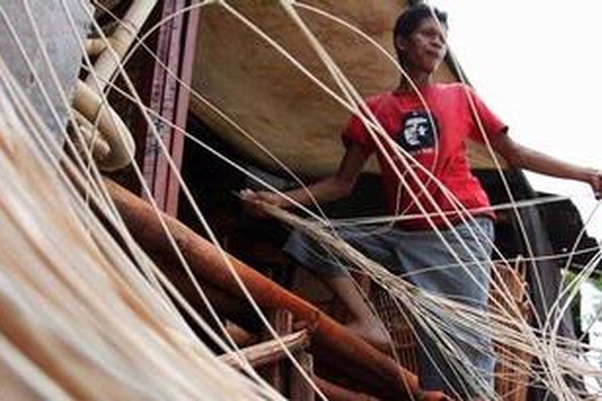 Sarbani, perajin mebel rotan asal Cirebon mempersiapkan rotan untuk dianyam menjadi kursi di bengkel produksi di kawasan Jalan Kalimalang, Jakarta Timur, Selasa (25/10/2011).
