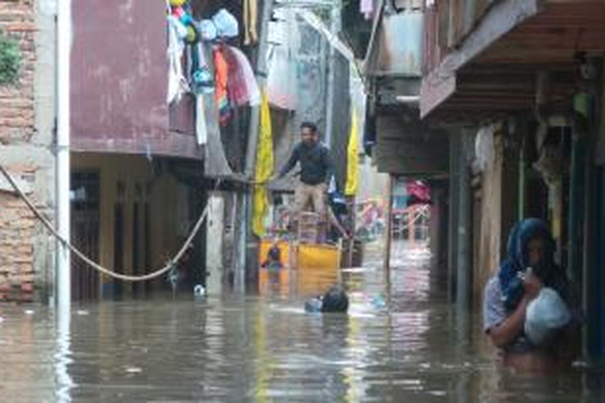 Warga Kampung Pulo, Jatinegara, Jakarta Timur memanfaatkan perahu dari gabus untuk menembus banjir yang menggenangi tempat tinggal mereka. Jumat (6/12/2013).