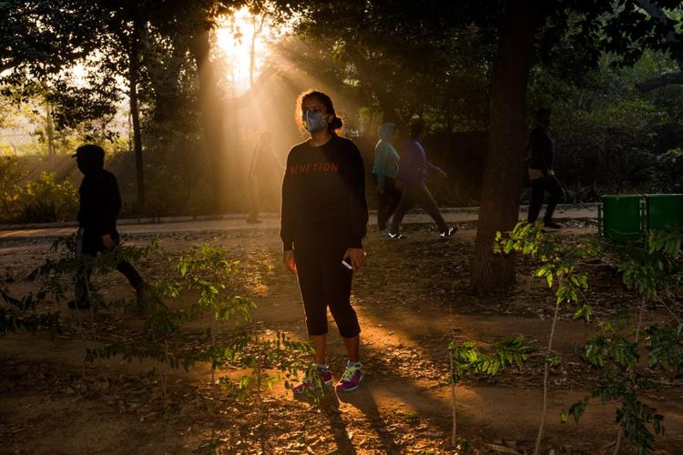 Seorang wanita muda memakai masker ketika berjalan-jalan di Taman Lordi pada pagi hari
