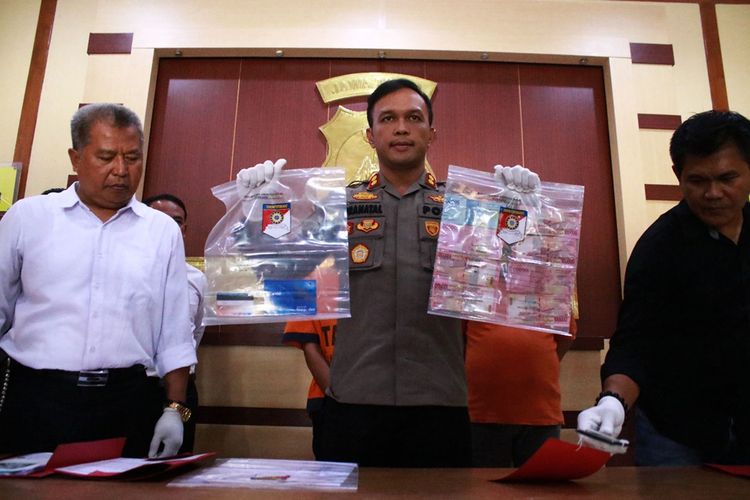 Kapolres Ngawi AKBP Pranatal Hutajulu memperlihatkan  sejumlah barang bukti kasus pemerasan dengan modus postingan foto bugil di media sosial.