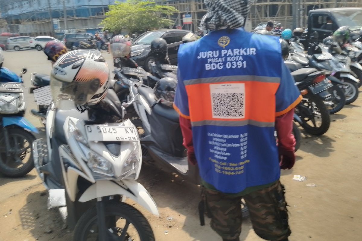 Seorang juru parkir di Jalan Cikapundung, Kota Bandung yang memakai rompi pembayaran via QRIS, Jumat (11/10/2024).