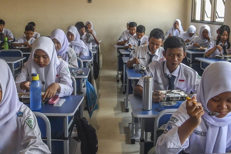 Siswa makan program Makan Bergizi Gratis (MBG) di SMP Negeri 13 Depok, Jawa Barat, Senin (6/10/2025). SPPG Cinere melibatkan puskesmas dan usaha kesehatan sekolah (UKS) untuk memantau secara berkala Satuan Pelayanan Pemenuhan Gizi (SPPG) atau dapur MBG guna memastikan pemenuhan gizi serta antisipasi kasus keracunan. 