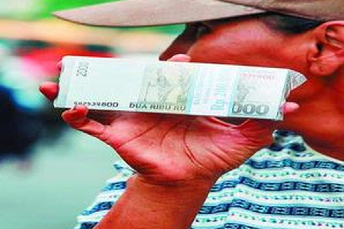 Pedagang uang receh di kawasan Stasiun Kota, Sabtu (5/9), memamerkan uang pecahan Rp 2.000. Menjelang Lebaran, uang baru yang dikeluarkan Bank Indonesia ini banyak diminati masyarakat. BI menyediakan uang pecahan Rp 2.000 dengan jumlah Rp 1,8 triliun. BI memperkirakan, kebutuhan uang kartal menjelang Lebaran naik 170 persen atau mencapai Rp 54,2 triliun dibandingkan dengan kebutuhan hari-hari biasa.