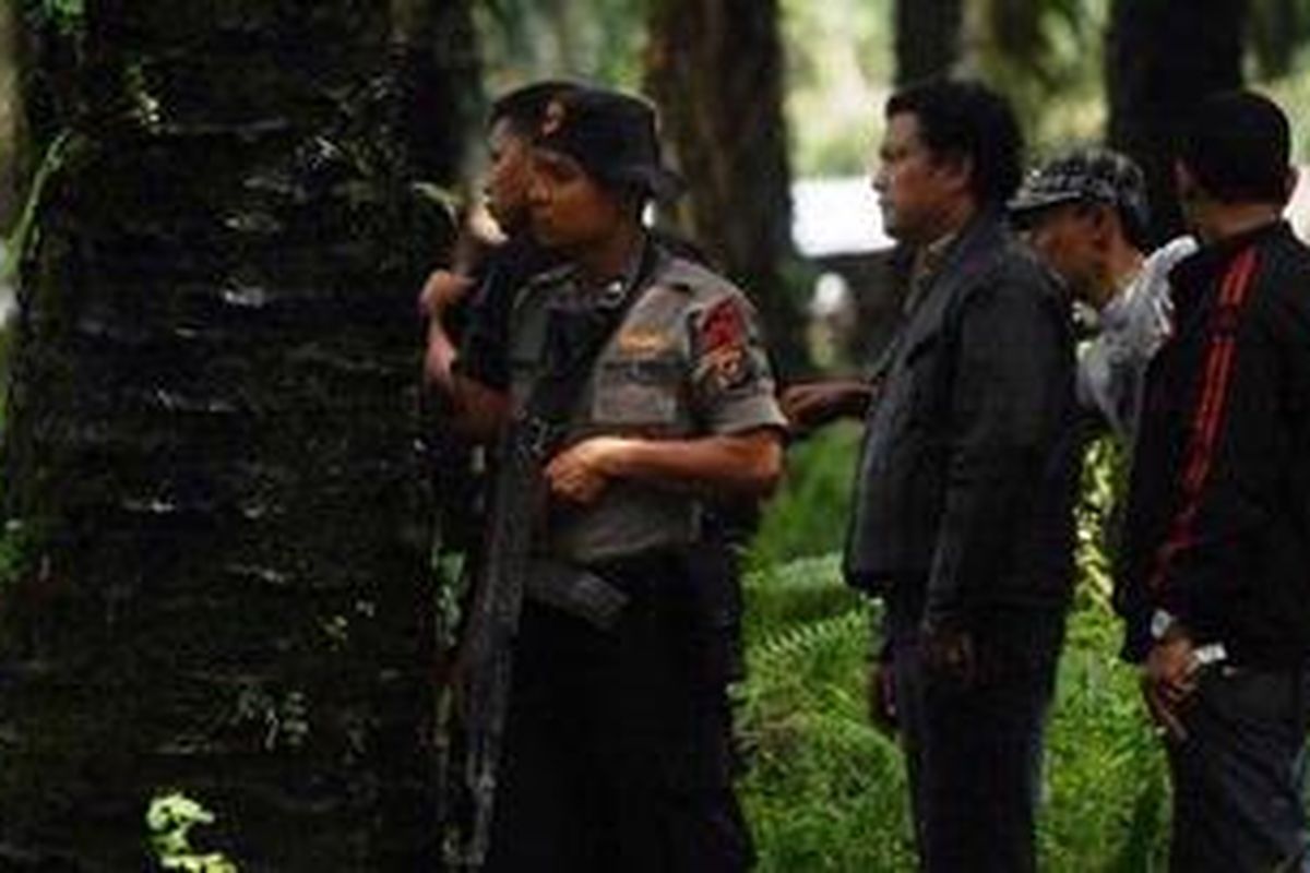 Polisi bersiaga dalam kontak senjata di perkebunan kelapa sawit Dusun III Pondok Sebrang, Desa Martebing, Kecamatan Dolok Masihul, Serdang Bedagai, Sumut (3/10/2010). Dalam kontak sejata tersebut, dua tersangka perampok Bank Niaga Medan tewas. 