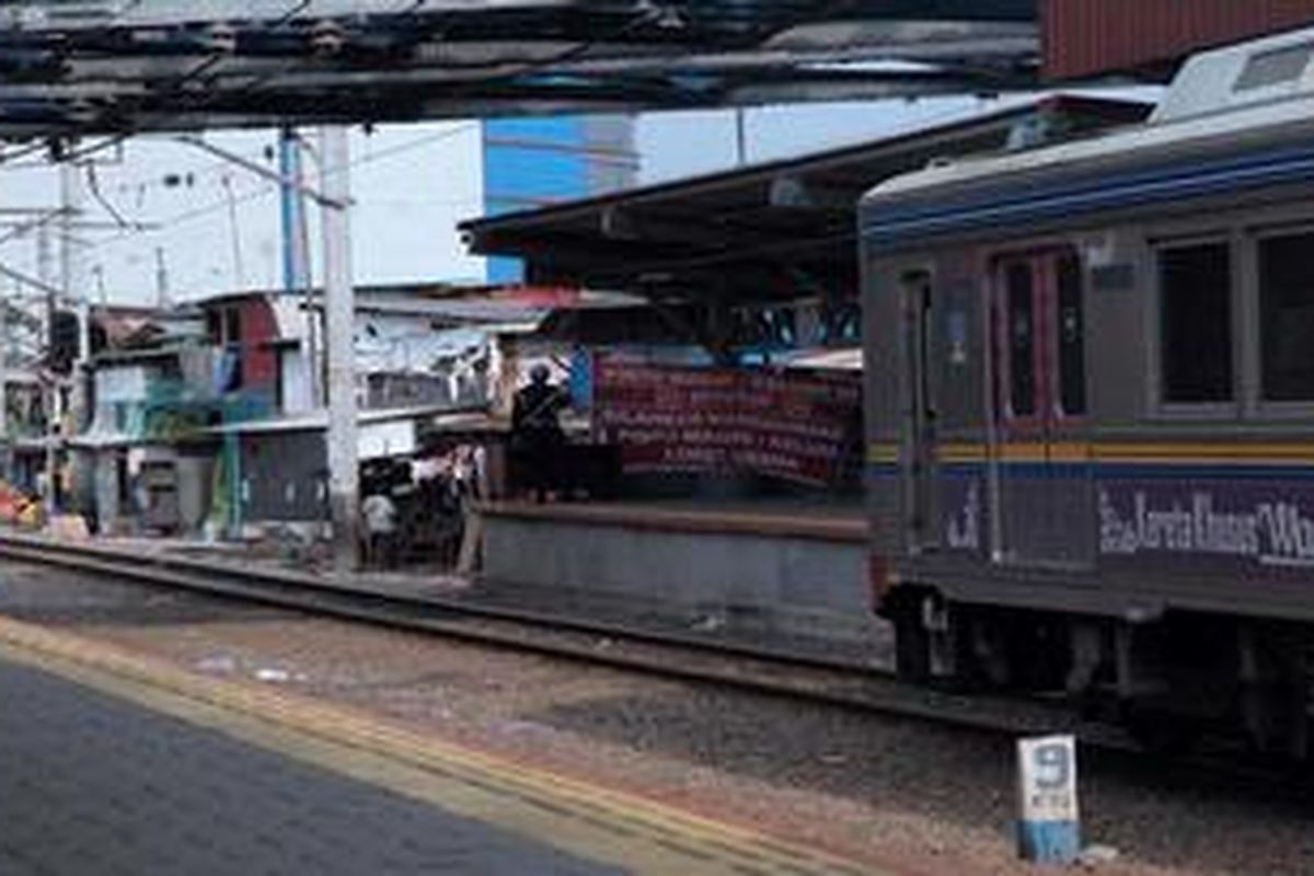 KRL Comuter Line berhenti di Stasiun Kampung Bandan, Jakarta Utara, untuk menaik turunkan penumpang, Jumat (10/5/2013). Stasiun ini berada di antara pusat perbelanjaan dan pemukiman kumuh warga.
