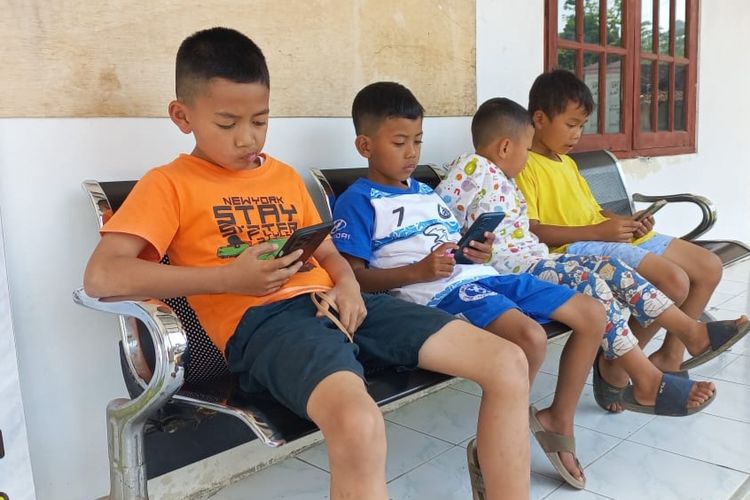 Anak-anak 'menumpang' internet gratis di Balai Desa Sepakung untuk melihat film kartun dari ponsel mereka