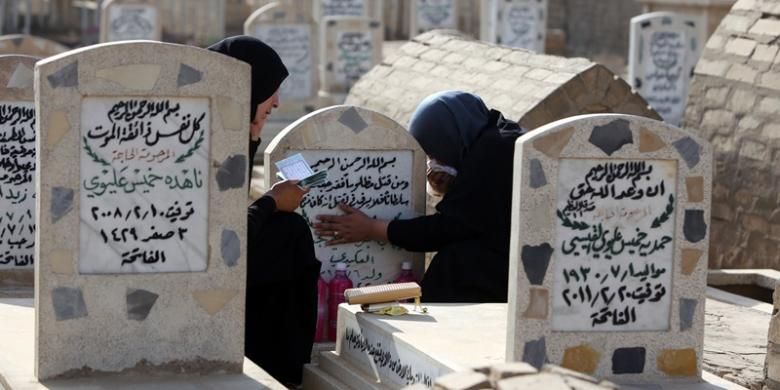 Seorang perempuan Irak mendatangi makam keluarganya di hari raya Idul Adha. Sebuah survei menyebut korban tewas akibat perang dan kekerasan di Irak sejak invasi AS pada 2003 hingga 2011 mencapai 460.000 orang.