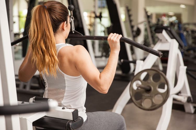 Ilustrasi menggunakan alat lat pulldown machine.