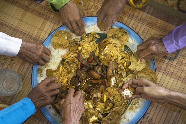Ilustrasi warga makan bersama dalam tradisi ambengan untuk memperingati hari besar Islam.