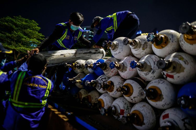 Officers unload oxygen-filled cylinders from trucks at the Oxygen Rescue Emergency Post, National Monument (Monas) area, Central Jakarta, Tuesday, July 6, 2021. A total of 132 oxygen cylinders from the Industrial Gas Factory (PGI) belonging to Krakatau Steel for 12 hospitals in Jakarta provided by the Jakarta Province today in line with the high number of active Covid-19 cases in Jakarta.
