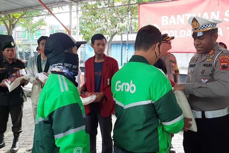 Sejumlah pengemudi ojek online mendapatkan bantuan sosial berupa 5 kilogram beras dari pihak kepolisian, di kawasan Blok T, Kabupaten Blora, Jawa Tengah, Jumat (9/9/2022)