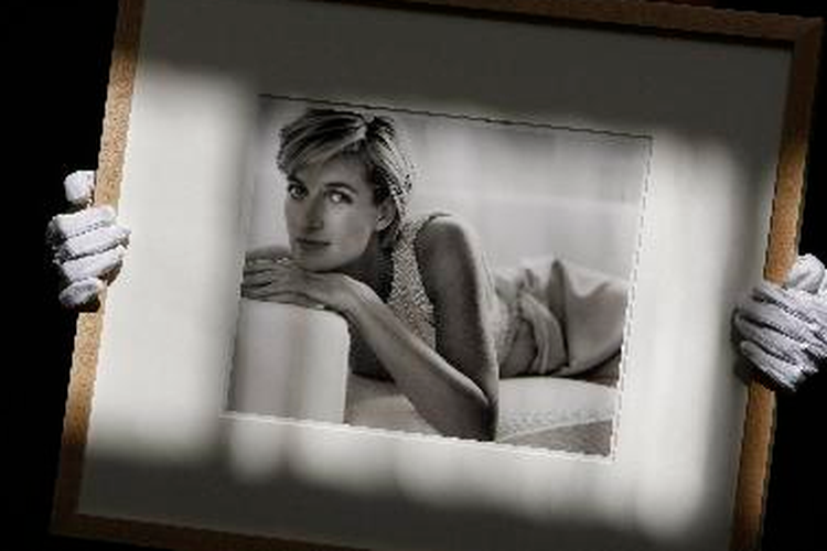 Seorang pegawai balai lelang Christie memegang foto mendiang Putri Diana dari Inggris, yang diambil oleh Mario Testino (1997) di tempat lelang di London, Rabu (19/5/2010). Foto ini dihargai 18.000 poundsterling sampai 22.000 poundsterling atau senilai sekitar Rp 300 jutaan.