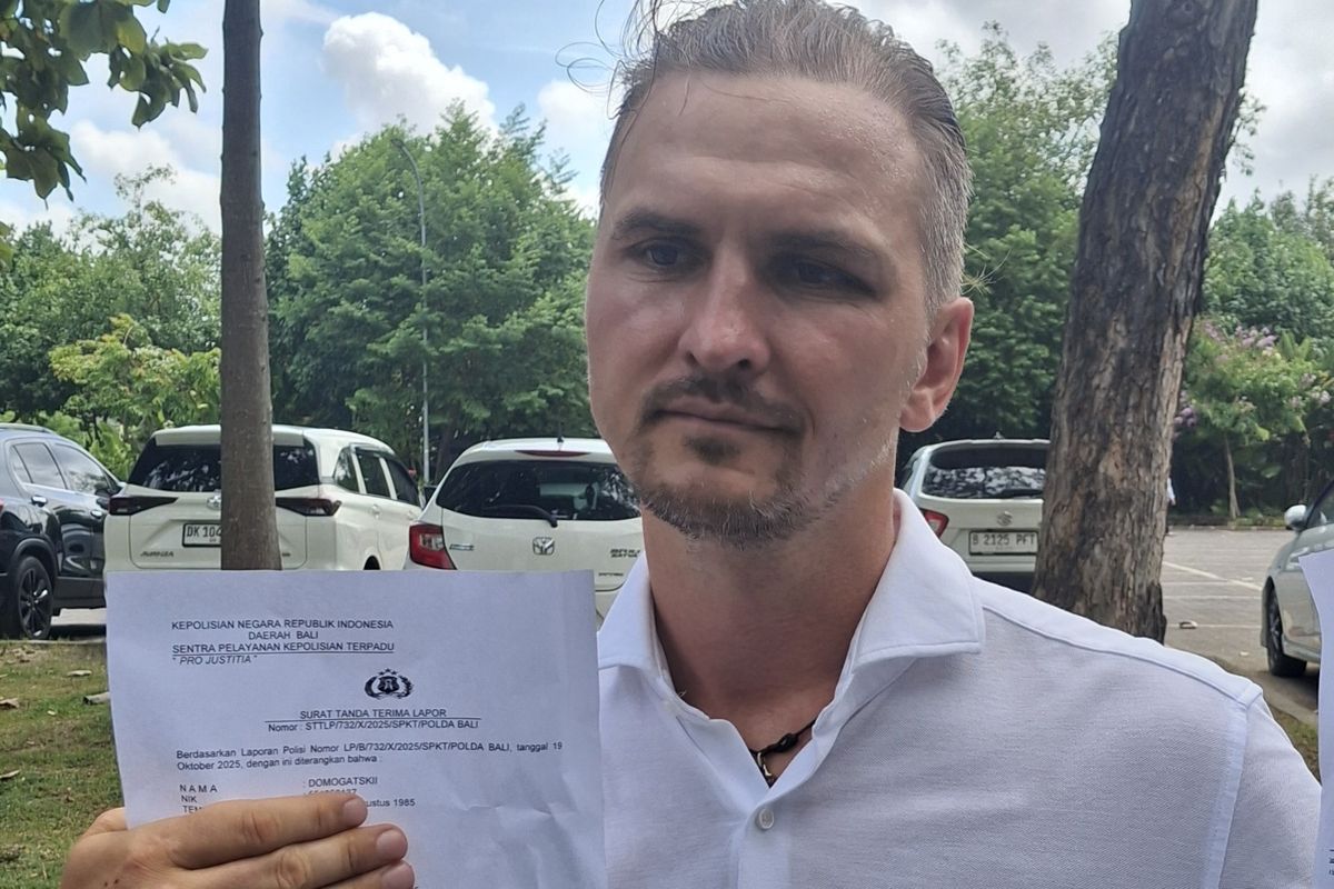 Sergeii Domogastkii (40), WNA asal Rusia saat menunjukan surat laporan polisi terkait peristiwa penculikan dan penganiayaan yang dialaminya, pada Selasa (21/10/2025). KOMPAS.com/ Yohanes Valdi Seriang Ginta