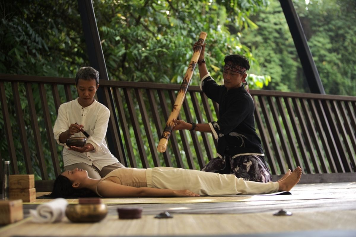 Sesi yoga dan sound healing yang diiringi musik etnik di Riverside Deck. 