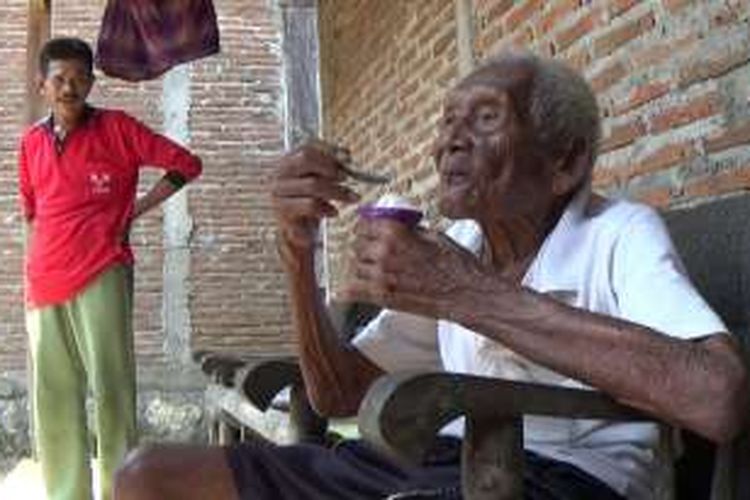 Suparman Sodimedjo atau Mbah Gotho tengah memakan es krim di rumahnya di Klaten, Jawa Tengah, Senin (29/8/2016).