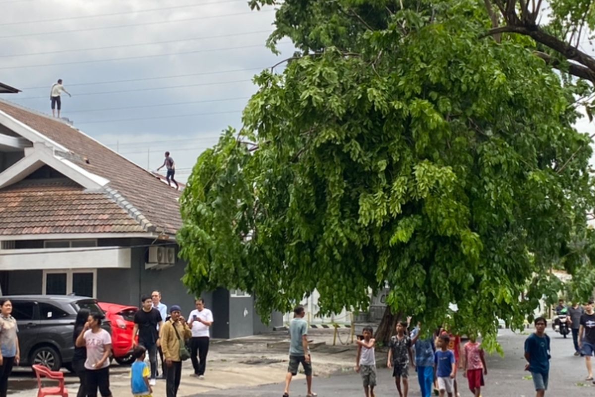 Warga tampak berhamburan keluar usai hujan disertai angin kencang, di Surabaya, Jumat (29/11/2024).