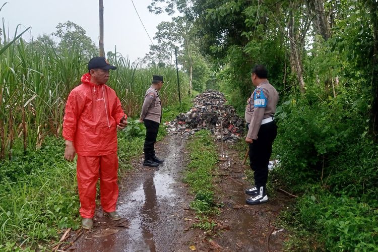 Anggota kepolisian saat mengecek tumpukan sampah menuju pemakaman di Dusun Boropanggung, Desa Banjararum, Kecamatan Singosari, Kabupaten Malang.