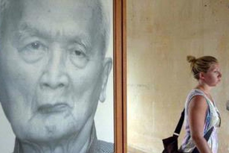 Seorang wisatawan melintas di depan foto salah seorang mantan pemimpin Khmer Merah Nuon Chea di Museum Genosida Kamboja di Phnom Pehn. Nuon Chea (86) kini tengah manjalani sidang kejahatan perang.
