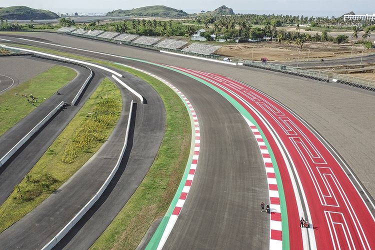 Foto udara pekerja menyelesaikan pengecatan ornamen Pertamina Mandalika International Street Circuit di KEK Mandalika, Kecamatan Pujut, Praya, Lombok Tengah, NTB, Jumat (5/11/2021). Pengecatan sudut trek, kerb dan tepian trek sirkuit Mandalika menggunakan tiga warna penting yakni warna merah putih yang menandakan kerb yang berfungsi sebagai pemandu pembalap di lintasan dan warna hijau yang merupakan track limit atau pembatas trek yang ketika pembalap menyentuh garis tersebut akan dikenakan penalti. ANTARA FOTO/Ahmad Subaidi/aww.