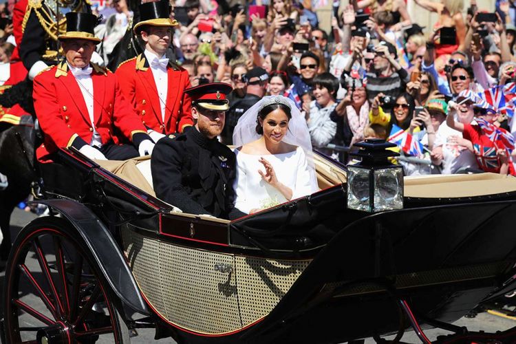 Pangeran Harry dan Meghan Markle menaiki kereta kencana Ascot Landau setelah pemberkatan pernikahan di Windsor, Inggris, Sabtu (19/5/2018). Sebanyak 600 tamu undangan menghadiri jamuan makan siang dan makan malam pada acara resepsi, ditambah 2.640 tamu dari warga biasa yang akan menimati teh dan kudapan di Istana Windsor.