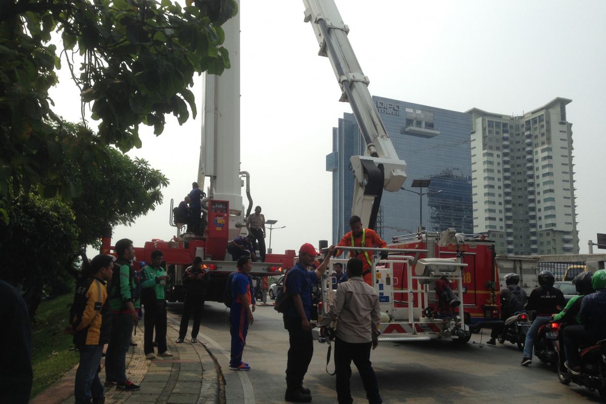 Para petugas pemadam kebakaran usai bernegosiasi dengan Agustinus (48), yang sejak pagi tadi memanjat baliho di samping ruas Jalan Gatot Subroto, Selasa (16/5/2017).