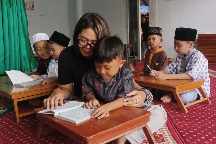 Wiwin (34), sedang mendampingi seorang anak untuk mengaji di Musalla yang dia bangun di kawasan eka lokalisasi Payo Sigadung, RT 05, Gang V, Kelurahan Rawasari, Alam Barajo, Kota Jambi, Senin (12/5/2025). Wiwin adalah anak mantan mucikari yang ingin mengubah Payo Sigadung dari kegiatan prostotusi.