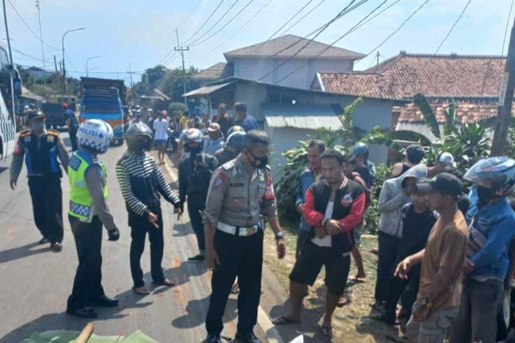 Petugas Unit Laka Polsek Cibungbulang sedang mengevakuasi seorang remaja berinisial MRB (15) yang tewas terlindas dump truk di Jalan Raya Umum Cibungbulang, Kabupaten Bogor, Jawa Barat, Rabu (22/9/2021).