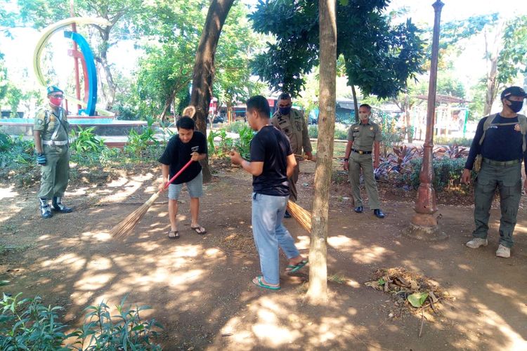 Warga Semarang dihukum menyapu taman Sampangan oleh petugas Satpol PP karena tak pakai masker, Selasa (18/8/2020).