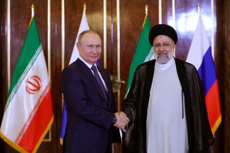 Gambar selebaran yang disediakan oleh kepresidenan Iran ini menunjukkan Presiden republik Islam Ebrahim Raisi (kanan) menyambut Presiden Rusia Vladimir Putin di Teheran pada 19 Juli 2022.