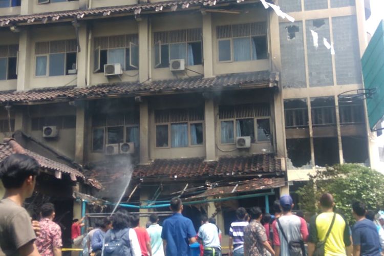 Sejumlah warga berbondong-bondong memadamkan api yang kembali muncul di lantai 2 SMK Yadika 6 Pondok Gede, Bekasi, Selasa (19/11/2019).