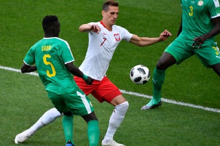 Arkadiusz Milik mencoba melewati kawalan Idrissa Gueye pada pertandingan Polandia vs Senegal di Stadion Spartak, 19 Juni 2018. 