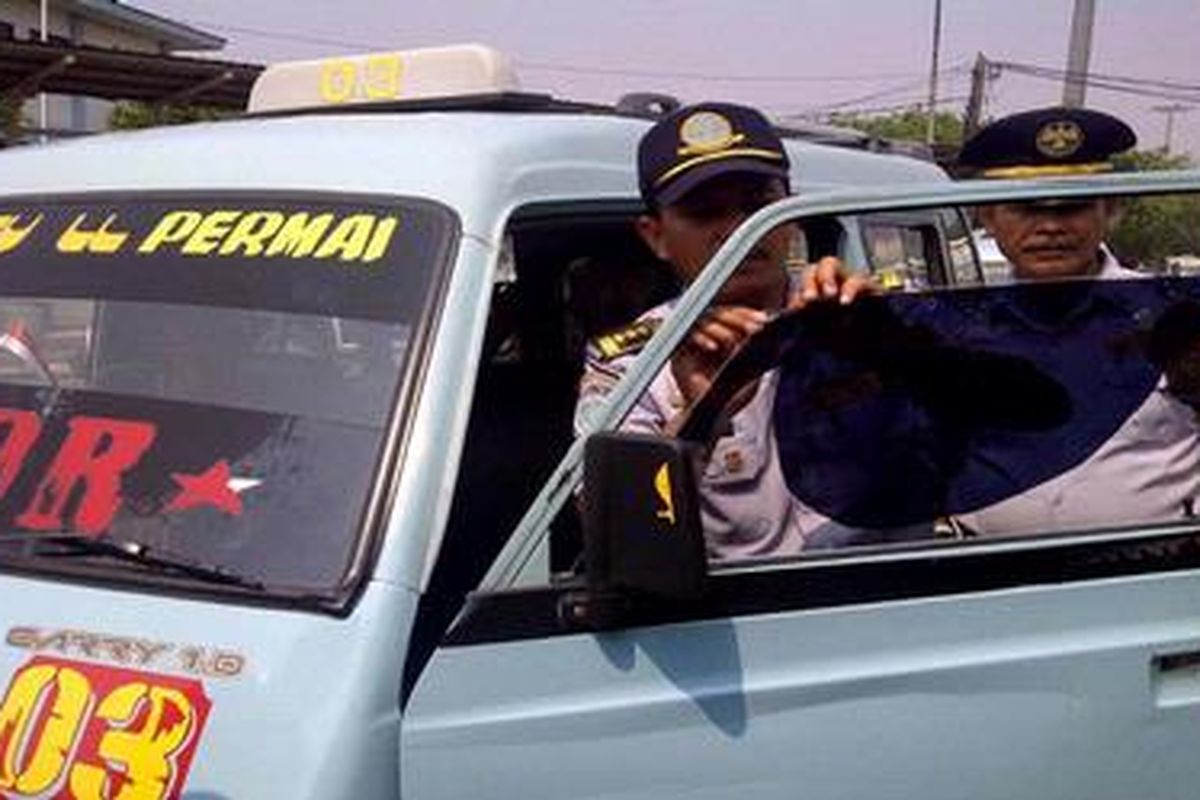 Sebuah angkotan kota di Terminal Tanjung Priok terjaring razia kaca gelap, Senin (19/9/2011) siang. Oleh petugas, kafa film yang terlalu gelap itu kemudian disobek dan dicabut.