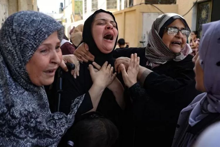 Para perempuan berkabung di pemakaman anggota keluarganya yang tewas akibat serangan balasan Israel pada 8 Oktober silam. 