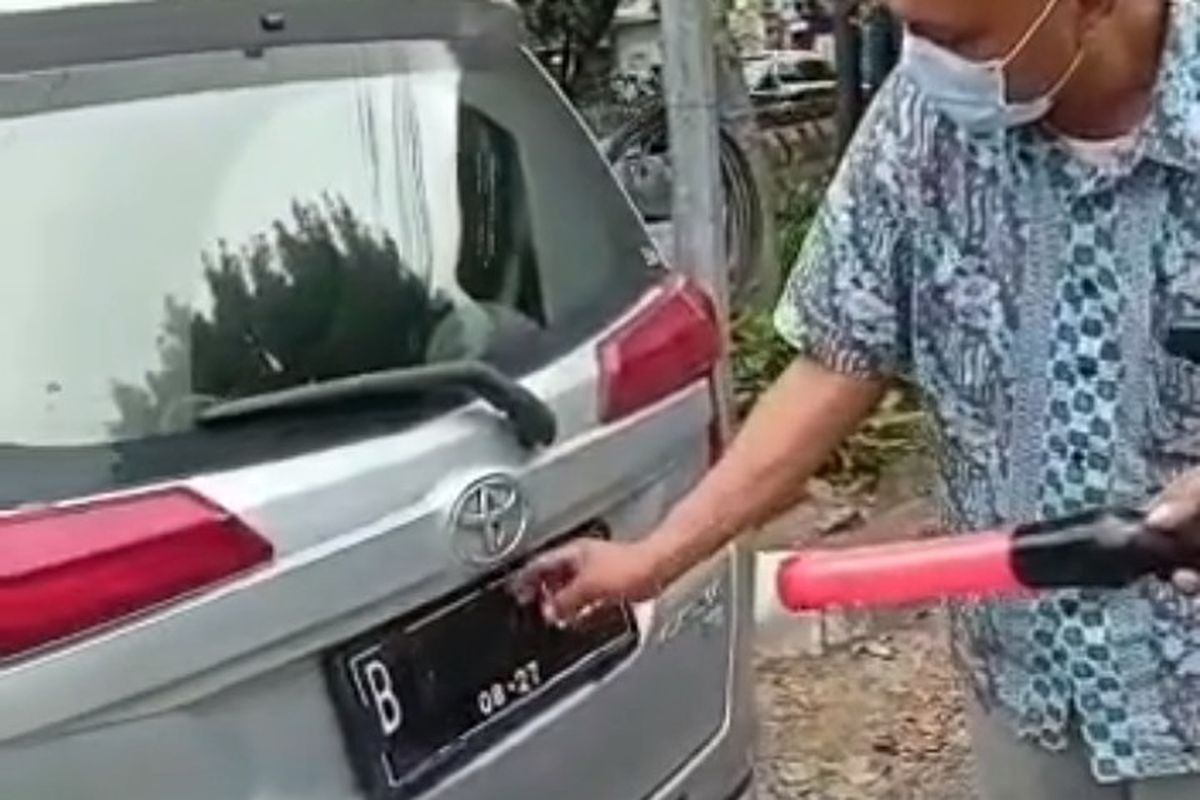 Polisi memberhentikan pengemudi mobil yang menutupi pelat nomor kendaraan menggunakan lakban untuk menghindari tilang elektronik. 